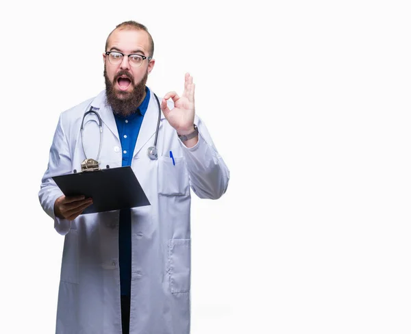 若い医者優秀なシンボルの指で サインをして孤立した背景にクリップボードを保持している男 — ストック写真