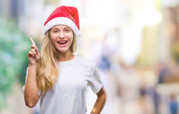 年轻美丽的金发女子戴着圣诞节帽子在孤立的背景指向手指与成功的想法 退出和快乐 第一个 — 图库照片