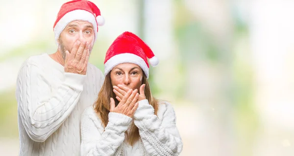 中年ヒスパニック系カップルが孤立した背景のミスのための手で口を覆っているショックを受けた上クリスマス帽子をかぶっています 秘密の概念 — ストック写真