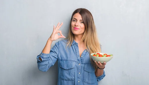 Jovem Mulher Adulta Sobre Parede Grunge Cinza Comendo Salada Tomate — Fotografia de Stock