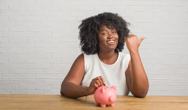 Jonge African American Vrouw Zittend Tafel Houden Piggy Bank Aan — Stockfoto