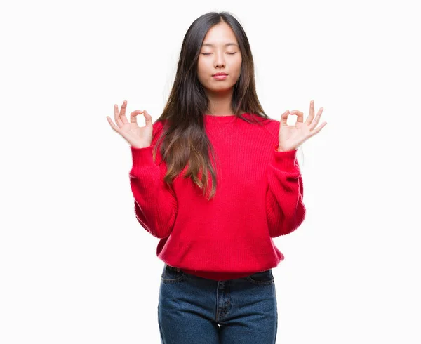 若いアジア女性着て冬セーター孤立した背景にリラックスして瞑想の指ジェスチャーをやって閉じた目を浮かべてします ヨガの概念 — ストック写真