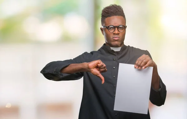 Young african american priest man over isolated background holding blank paper with angry face, negative sign showing dislike with thumbs down, rejection concept