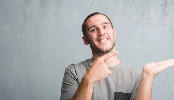 Homem Caucasiano Jovem Sobre Parede Grunge Cinza Muito Feliz Apontando — Fotografia de Stock