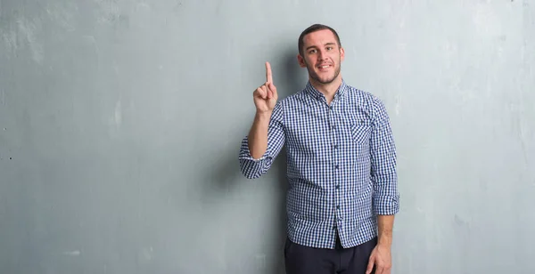 Joven Caucásico Hombre Sobre Gris Grunge Pared Mostrando Apuntando Hacia — Foto de Stock