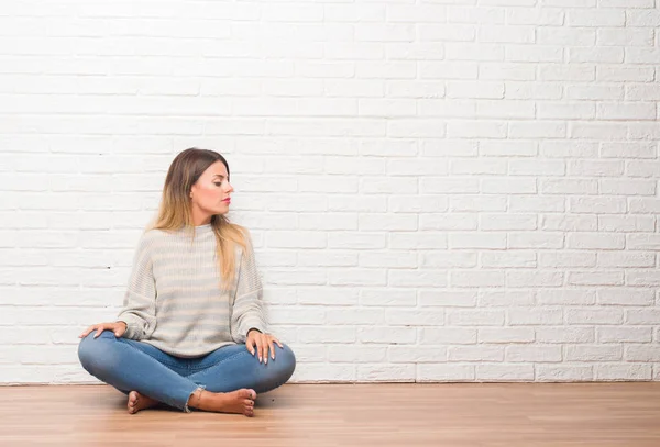 Junge Erwachsene Frau Sitzt Auf Dem Boden Über Weißen Backstein — Stockfoto