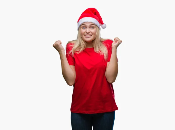 年轻的高加索妇女戴着圣诞帽在孤立的背景庆祝惊讶和惊讶的成功与手臂抬起和睁大眼睛 优胜者概念 — 图库照片