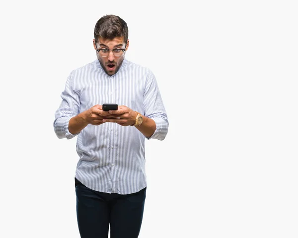 年轻英俊的人发短信使用智能手机在孤立的背景下吓坏了惊讶的脸 害怕和兴奋与恐惧的表情 — 图库照片