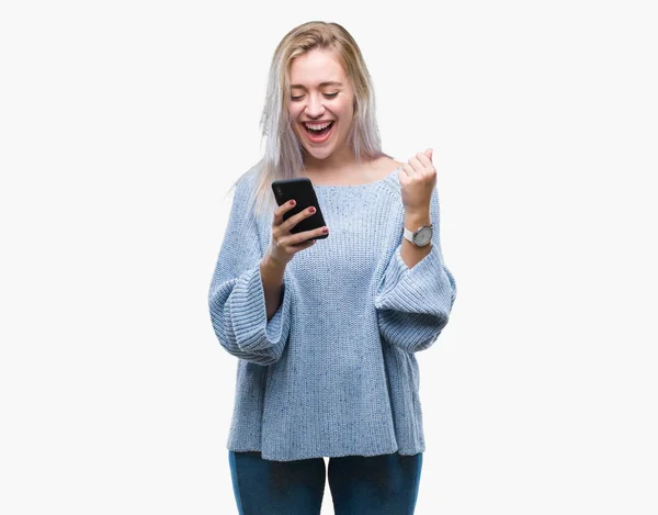 年轻的金发碧眼的女人发短信发送消息使用智能手机在孤立的背景尖叫骄傲和庆祝胜利和成功非常兴奋 欢呼的情感 — 图库照片