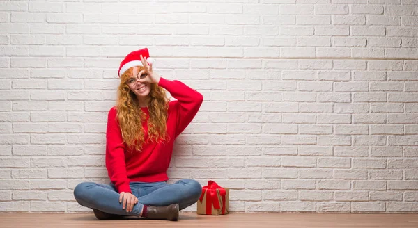 Young Redhead Woman Sitting Brick Wall Wearing Christmas Hat Doing — Stock Photo, Image