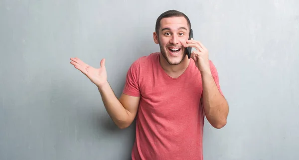 Giovane Uomo Caucasico Sul Muro Grigio Grunge Parlando Telefono Molto — Foto Stock