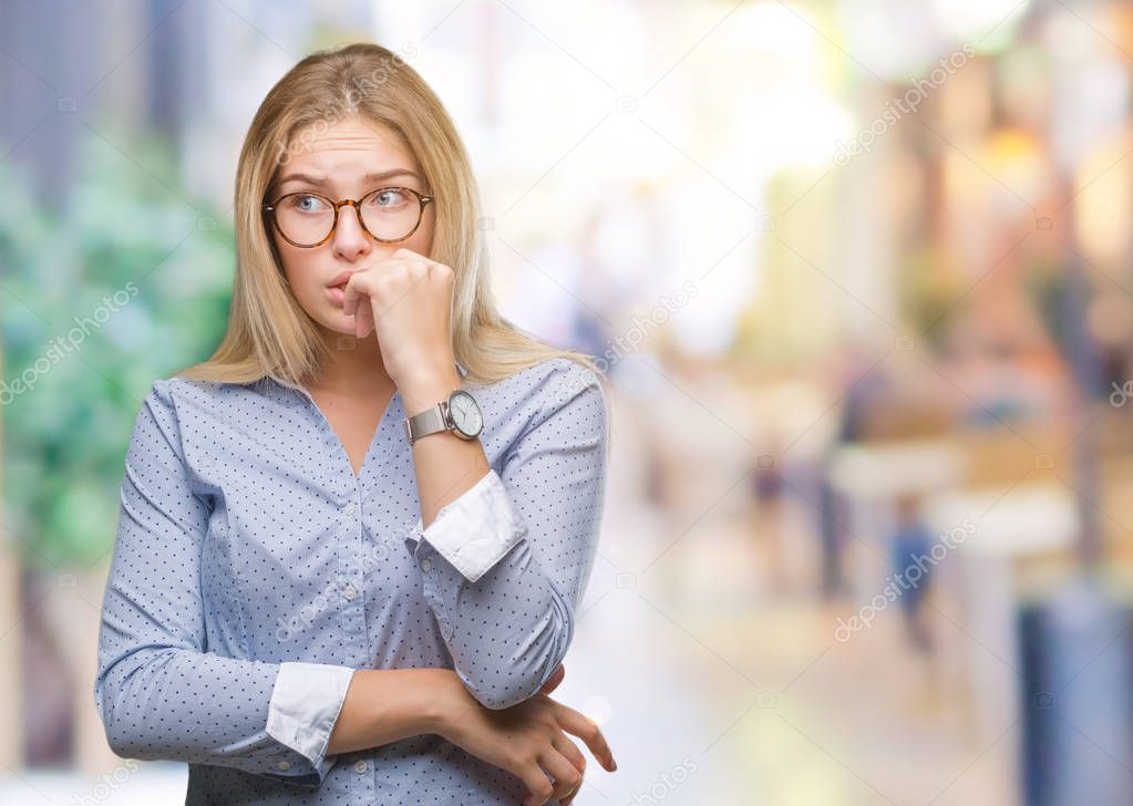 Young caucasian business woman wearing glasses over isolated background looking stressed and nervous with hands on mouth biting nails. Anxiety problem.
