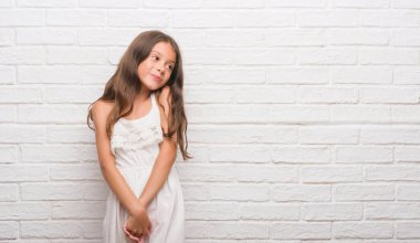 Genç İspanyol çocuğun üzerinde beyaz tuğla duvar uzak tarafına gülümseme ile yüzünde, doğal ifade arıyorum. Kendine güvenen gülüyor.