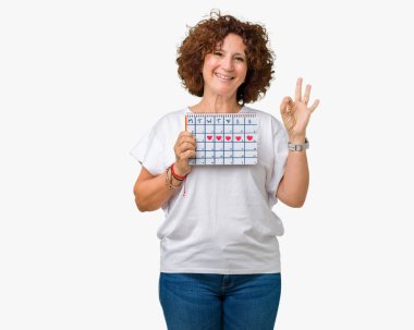 Adet takvim parmak, mükemmel sembolü ile ok işareti yapıyor izole arka plan üzerinde tutan orta ager üst düzey kadın