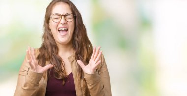 Başarı kollarını kaldırdı ve heyecanlı çığlık gözleri kapalı elbise ve deri ceket kızgın ve çılgın izole arka plan kutlama üzerinde giyen güzel artı boyutu genç kadın. Kazanan kavramı