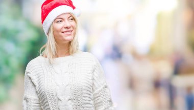 Üzerinde Noel şapka giyen genç güzel sarışın kadın arka plan uzak tarafına gülümseme ile yüzünde, doğal ifade arıyorum izole. Kendine güvenen gülüyor.
