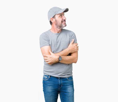 İkna ve kendinden emin yakışıklı orta yaş ağarmış komuta sizde Spor şapkası ile silah tarafına bakarak gülümseyen izole arka plan üzerinde çarpı işareti