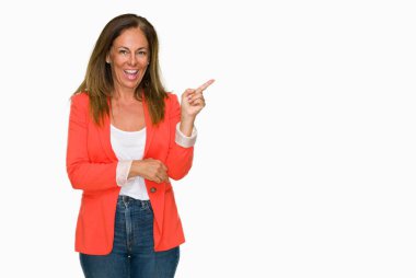 Kameraya bakarak yan el ve parmak ile işaret eden güzel orta yaş iş yetişkin kadın yüzünde kocaman bir gülümseme ile izole arka plan.