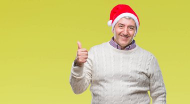 Hareketi el ile mutlu yaşasın yapıyor izole arka plan üzerinde Noel şapka giymiş yakışıklı komuta sizde. Kameraya bakarak başarı gösteren ile ifade onaylama.