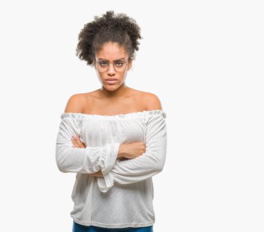 İzole arka plan şüpheci ve çapraz kolları olan yüzündeki gergin, onaylamayan ifade gözlüklü genç afro Amerikalı kadın. Negatif kişi.