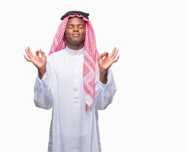 Geleneksel keffiyeh izole arka plan üzerinde giyen genç Arapça Afrika adam rahatla ve gülümseyen gözlerle kapalı parmak jestle meditasyon yapıyor. Yoga kavramı.