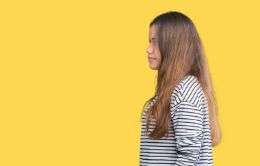 Genç güzel esmer kadın giyiyor çizgili süveter izole arka tarafına, seyir üzerinde dinlenmek doğal yüz emin gülümseme ile pozuyla profili.