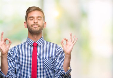 Genç yakışıklı iş adamı izole arka plan üzerinde dinlenmek ve gülümseyen gözlerle kapalı parmak jestle meditasyon yapıyor. Yoga kavramı.