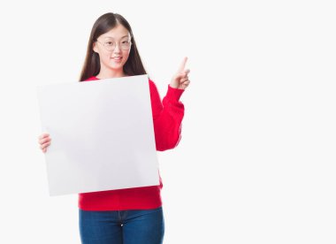 İzole arka plan boş afiş sürpriz bir fikir ya da soru gülen yüz, bir numara ile parmak işaret tutan genç Çinli kadın