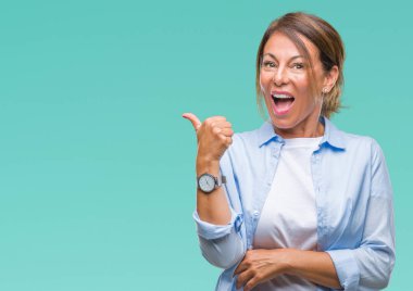 Orta yaş arıyor ve başparmak yanında yukarıyı mutlu yüz ile gülümseyen izole arka plan üzerine İspanyol kadın kıdemli.