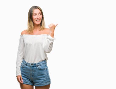 Seyir ve başparmak yanında yukarıyı mutlu yüz ile gülümseyen izole arka plan üzerinde genç güzel kadın.