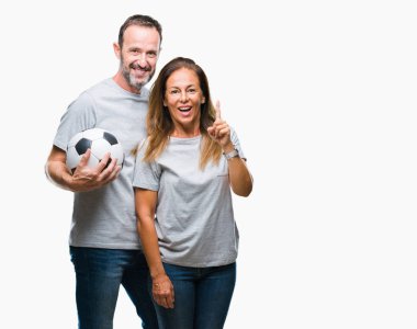 Futbol futbol tutan orta yaş İspanyol çift izole arka bir fikirle sürpriz üzerinden topu ya da gülen yüz, bir numara ile işaret parmağı soru