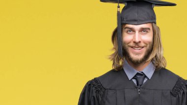 İzole arka plan ile bir mutlu ve serin üzerinden uzun saçlı Genç mezun yakışıklı yüzündeki gülümseme. Şanslı kişi.