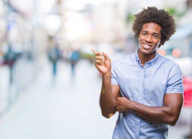 Kameraya bakarak yan el ve parmak ile işaret Afro Amerikalı adam yüzünde kocaman bir gülümseme ile izole arka plan üzerinde.