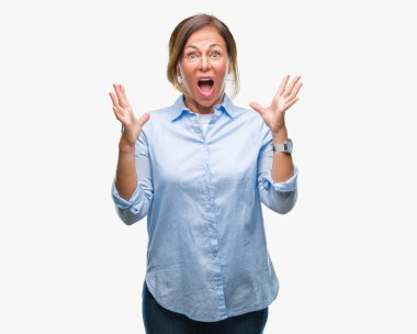 Orta yaş üst düzey İspanyol kadın deli kutluyor arka plan izole ve başarı için kaldırdı kollarını açarak hayrete ve heyecanlı çığlık gözleri açık. Kazanan kavramı