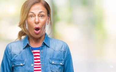 Orta yaş üst düzey İspanyol kadın izole arka plan korkuyor ve sürpriz ifade ile şok yüzünden korku ve yüz heyecanlı.