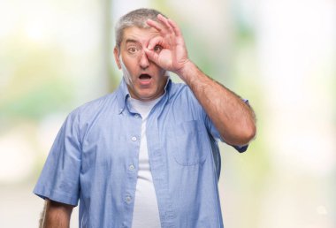 Sürpriz yüz, göz parmaklarının arasından seyir ile üst düzey yakışıklı ok jest yapıyor izole arka plan üzerinde şok. İmansız ifade.