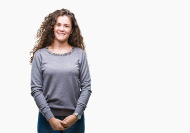 Güzel esmer kıvırcık saçlı Genç kız yüzünde mutlu ve güzel bir gülümseme ile izole arka plan üzerinde bir kazak giyiyor. Şanslı kişi.