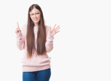 İzole arka planda gösterilen ve kendinden emin ve mutlu gülümseyerek ise altıncı parmak işaret eden oktan yukarı gözlüklü Genç Çinli kadın.