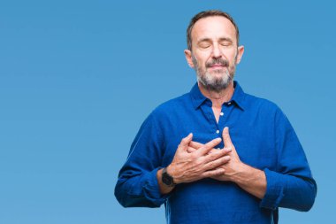 Orta yaş ağarmış komuta sizde ile gülümseyen izole arka plan üzerinde kapalı gözler ve yüzünde minnettar jest ile göğüs üzerinde eller. Sağlık kavramı.