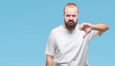 Mutsuz ve kızgın ret gösterilen ve başparmak aşağı hareketi ile negatif seyir izole arka plan üzerinde rahat t-shirt giyen genç beyaz hipster adam. Kötü ifade.