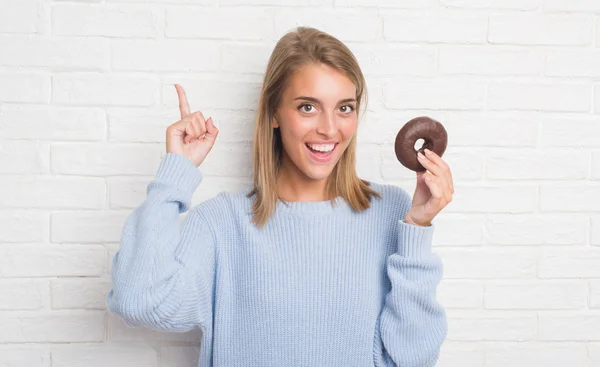 Hermosa Mujer Joven Sobre Pared Ladrillo Blanco Comiendo Donut Chocolate —  Fotos de Stock