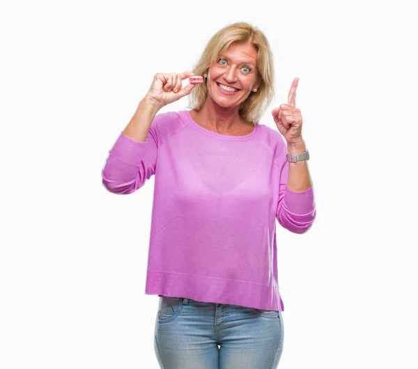 Mujer Rubia Mediana Edad Comiendo Galleta Macaron Rosa Sobre Fondo — Foto de Stock
