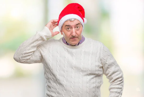 英俊的老人戴着圣诞节帽子在孤立的背景混淆和疑惑的问题 疑惑不定 用手在头上思考 沉思概念 — 图库照片