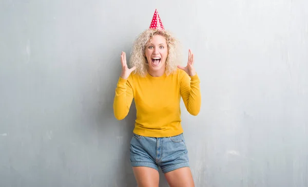 Jovem Loira Sobre Grunge Parede Cinza Usando Chapéu Aniversário Celebrando — Fotografia de Stock