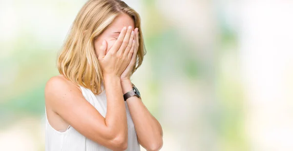 Beautiful young elegant woman over isolated background with sad expression covering face with hands while crying. Depression concept.