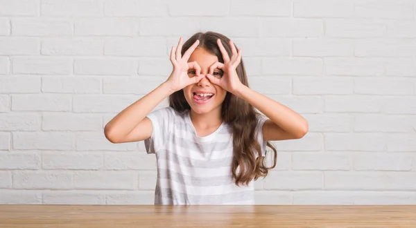 Evde Masaya Oturan Genç Spanyol Çocuğun Dilini Parmaklarının Arasından Baktığını — Stok fotoğraf