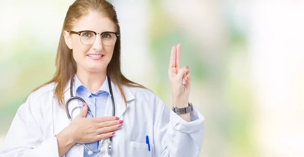 Middle age mature doctor woman wearing medical coat over isolated background Swearing with hand on chest and fingers, making a loyalty promise oath