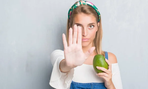 Hermosa Mujer Joven Sobre Pared Gris Grunge Sosteniendo Mango Fresco — Foto de Stock