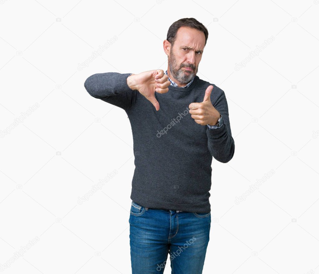 Handsome middle age senior man wearing a sweater over isolated background Doing thumbs up and down, disagreement and agreement expression. Crazy conflict