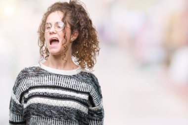 Güzel esmer kıvırcık saçlı Genç kız seksi bir ifadeyle, neşeli ve mutlu yüzünü kameraya bakarak göz kırpıyor izole arka plan üzerinde gözlük.